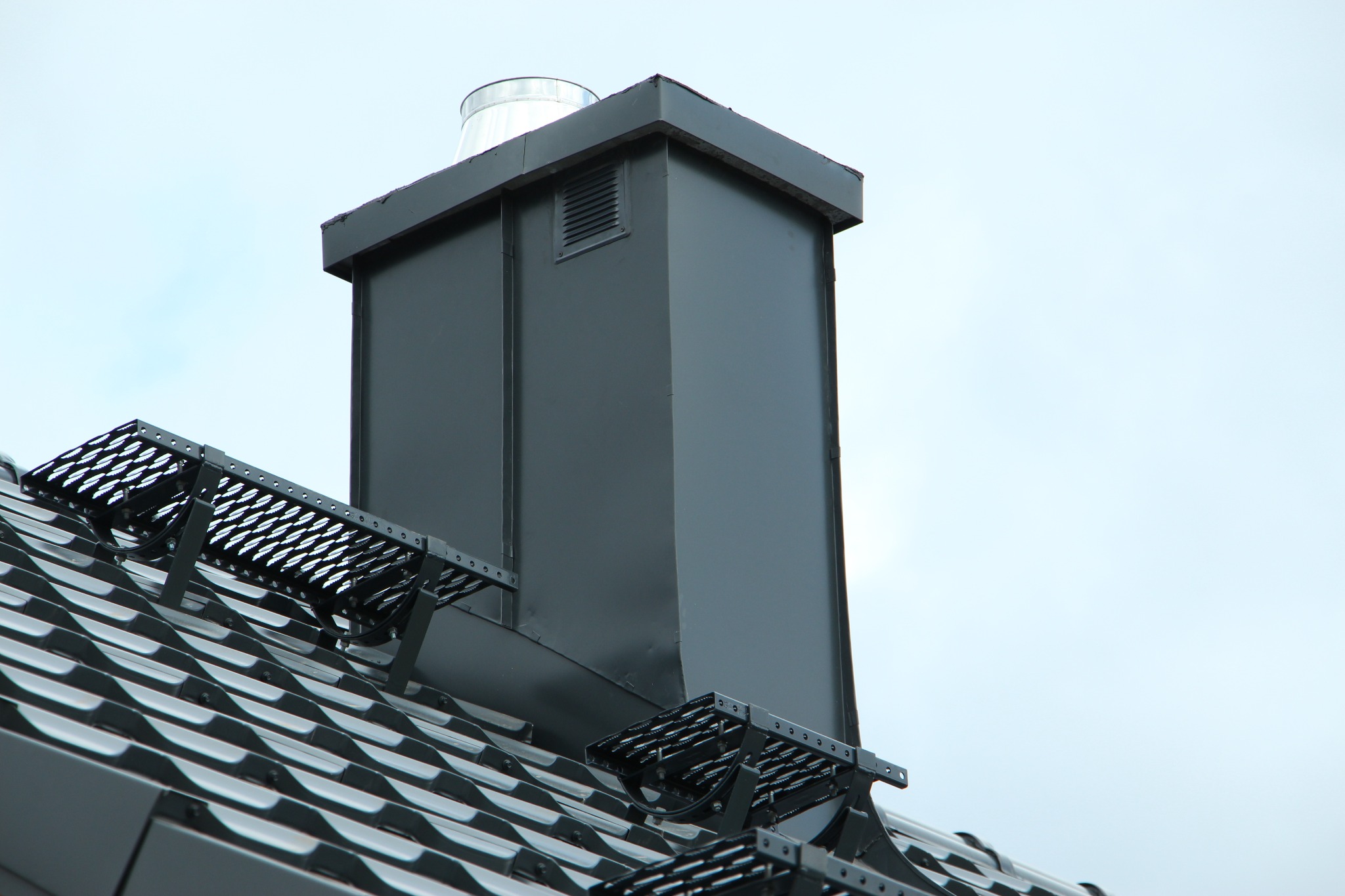 Komin obudowany blachą metodą na rąbek stojący (inaczej: podwójny rąbek).