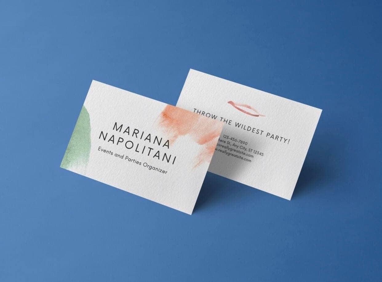 Dwie minimalistyczne wizytówki z akwarelowymi plamami w kolorach zieleni i pomarańczy na niebieskim tle, prezentujące dane kontaktowe firmy z Łodzi zajmującej się organizacją imprez.