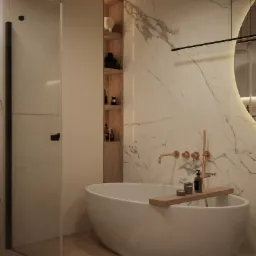 Nowoczesna łazienka z wolnostojącą wanną, marmurową ścianą, złotą armaturą i przeszklonym prysznicem.