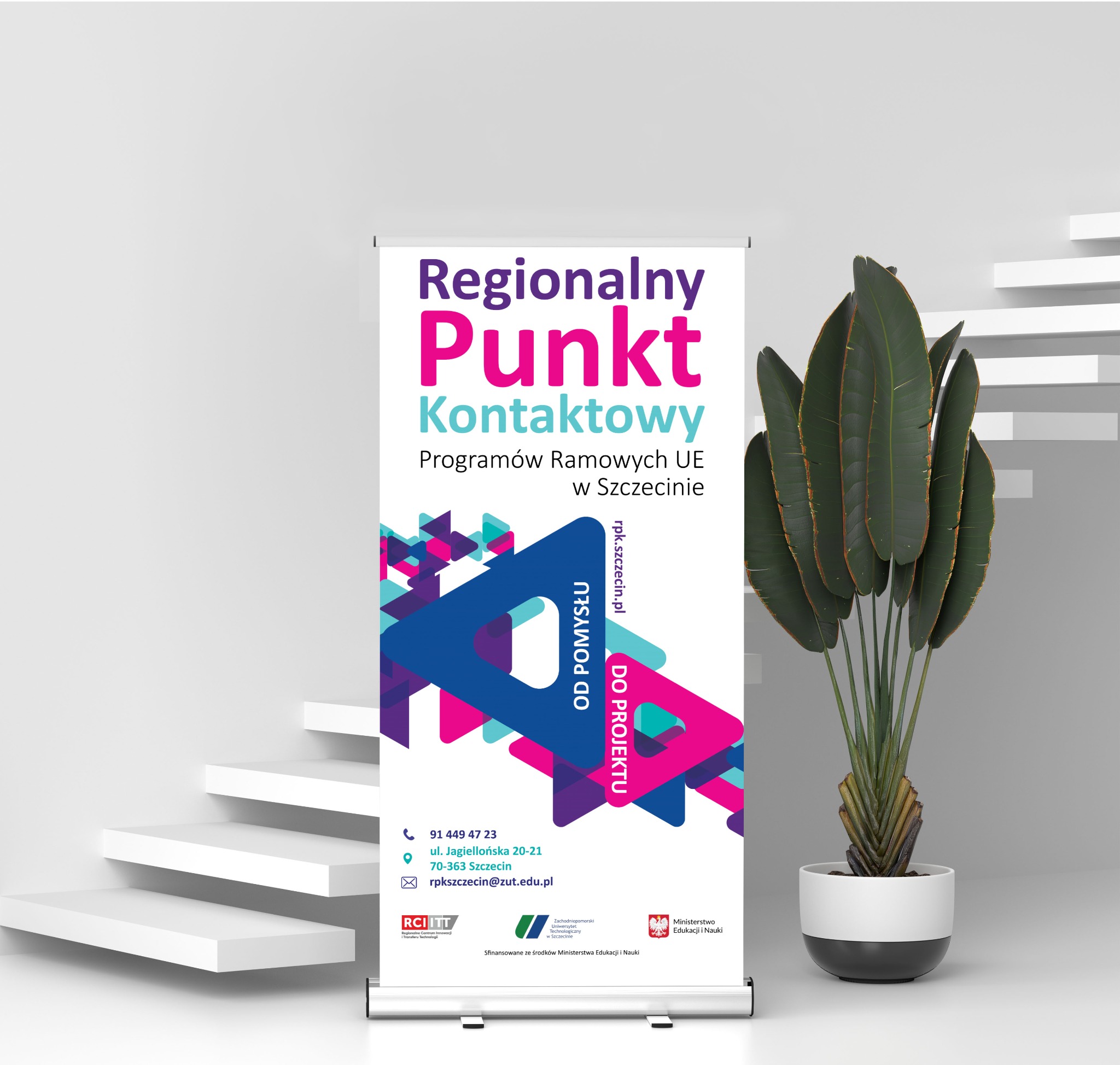 Roll-up reklamowy Regionalnego Punktu Kontaktowego Programów Ramowych UE w Szczecinie, z widocznymi danymi kontaktowymi i logotypami, ustawiony w minimalistycznym wnętrzu obok dekoracyjnej rośliny...