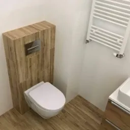 Nowoczesna łazienka z podwieszaną toaletą obudowaną płytkami imitującymi drewno, grzejnikiem drabinkowym i umywalką z szafką w odcieniach drewna.