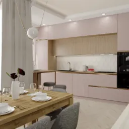 Jasna kuchnia z różowymi szafkami i drewnianymi akcentami, widok na stół jadalny z zastawą i dekoracyjnym wazonem z ciemnymi kwiatami, designerskie lampy wiszące z kulistymi kloszami.