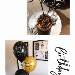 Dekoracje urodzinowe: balony z napisami 'Happy Birthday', 'Sto Lat!', '18th', pudełko z prezentami, świece na szklanych świecznikach, plakaty na ścianie, kompozycja na małym stoliku.