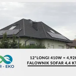 Dom jednorodzinny z zainstalowanymi panelami słonecznymi na dachu, model paneli LONGI 410W, falownik SOFAR 4,4 KTL-X, widok z poziomu ulicy w pochmurny dzień.