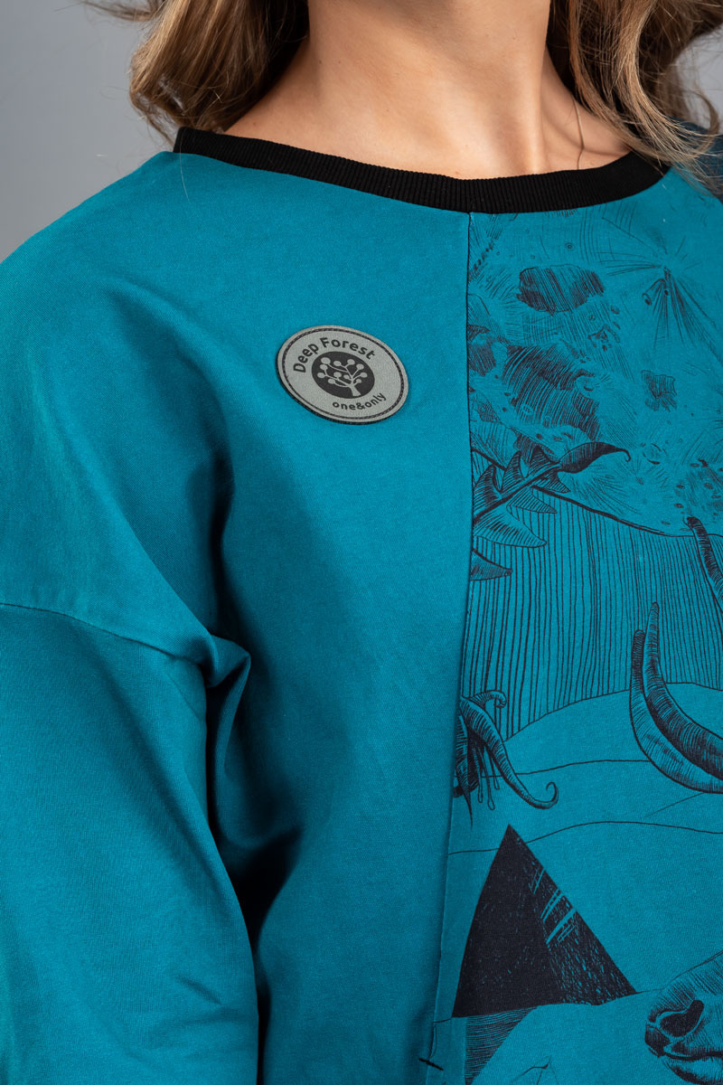 Turkusowa bluza z czarnym nadrukiem i naszywką 'Deep Forest' od firmy z Bielska-Białej, prezentująca połączenie gładkiej tkaniny i wzorzystego panelu.