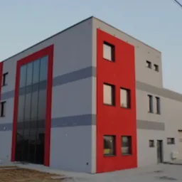 Nowoczesny budynek biurowy z szarą elewacją i czerwonymi akcentami, duże okna, widok z zewnątrz.