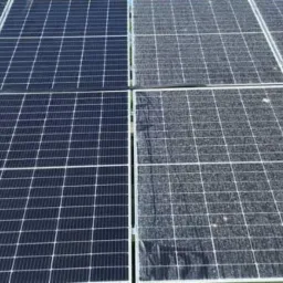 Częściowo wyczyszczone panele słoneczne, widoczna różnica między czystą a brudną powierzchnią, ukazująca skuteczność czyszczenia.