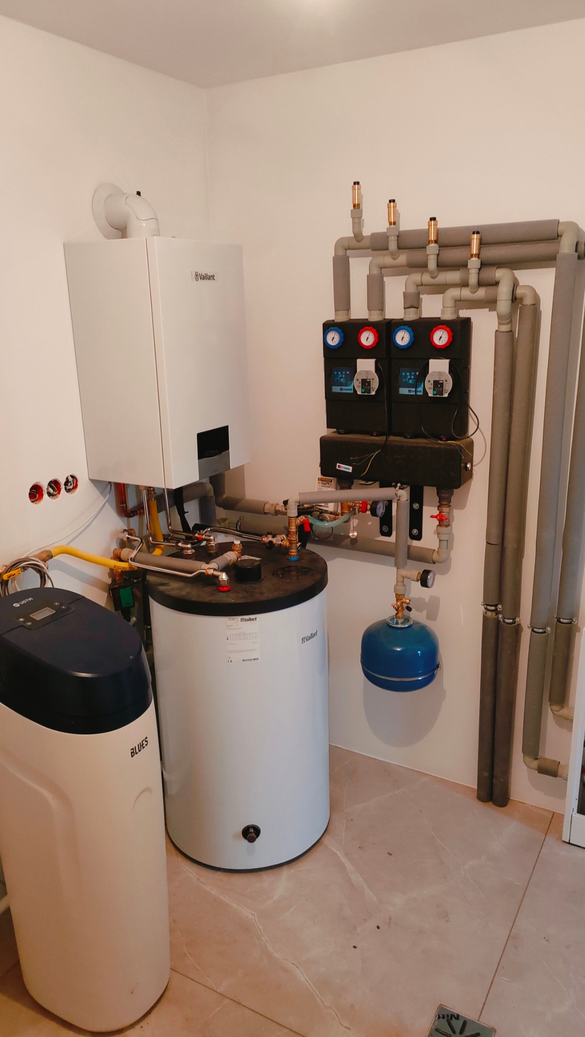 Kotłownia z zamontowanym piecem gazowym Vaillant, zasobnikiem ciepłej wody, stacją uzdatniania wody Blues i rozbudowaną instalacją hydrauliczną z izolowanymi rurami.