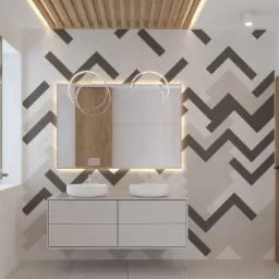 Nowoczesna łazienka z dwoma umywalkami nablatowymi, szafką z szufladami, lustrem z podświetleniem LED, oraz ścianą wyłożoną płytkami w geometryczny wzór chevron w odcieniach szarości i bieli.