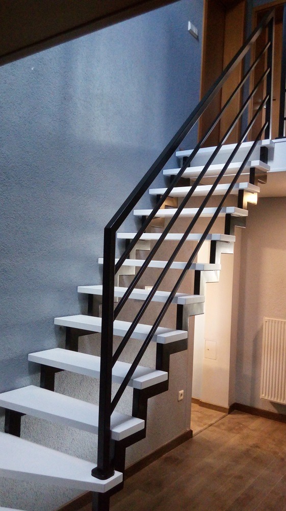 Schody na konstrukcji metalowej z białymi stopniami.