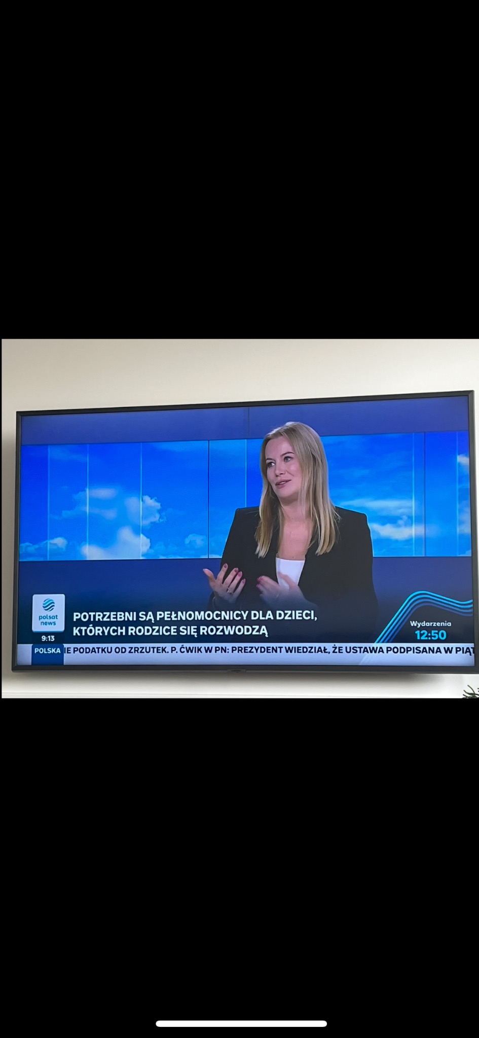 Adwokat rozwodowy z Torunia na ekranie telewizora podczas wywiadu o pełnomocnictwach dla dzieci w sprawach rozwodowych. Kadr z programu informacyjnego.