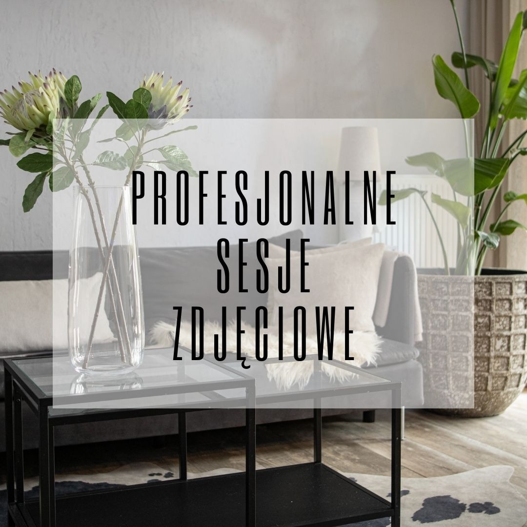 Nowoczesny salon z szarą sofą, szklanymi stolikami kawowymi z czarną ramą, wazonem z egzotycznymi kwiatami i dużą rośliną doniczkową w ozdobnej donicy, na podłodze skóra krowy.