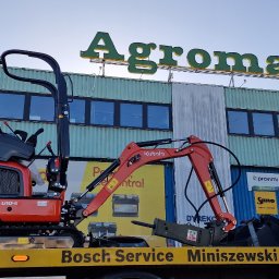 Sosaan - Czerwona minikoparka Kubota U10-5 na lawecie Bosch Service Miniszewski w Warszawie, na tle budynku z napisem Agroma.