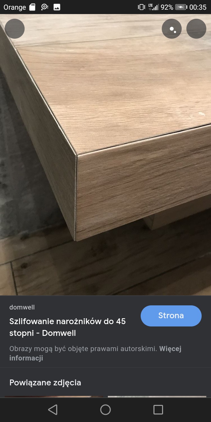 Detale wykończenia narożnika blatu z płytek drewnopodobnych, widoczne precyzyjne szlify i fuga, na tle podłogi w podobnym odcieniu.