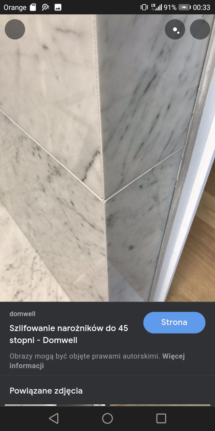 Precyzyjnie ułożone, szlifowane marmurowe płytki narożne w łazience, widoczne delikatne żyłki kamienia i biała fuga.