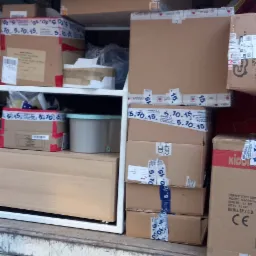 Wnętrze ciężarówki wypełnione kartonami i meblami podczas przeprowadzki, widoczny numer rejestracyjny pojazdu BS 49302 SP oraz baner z napisem PARTNER