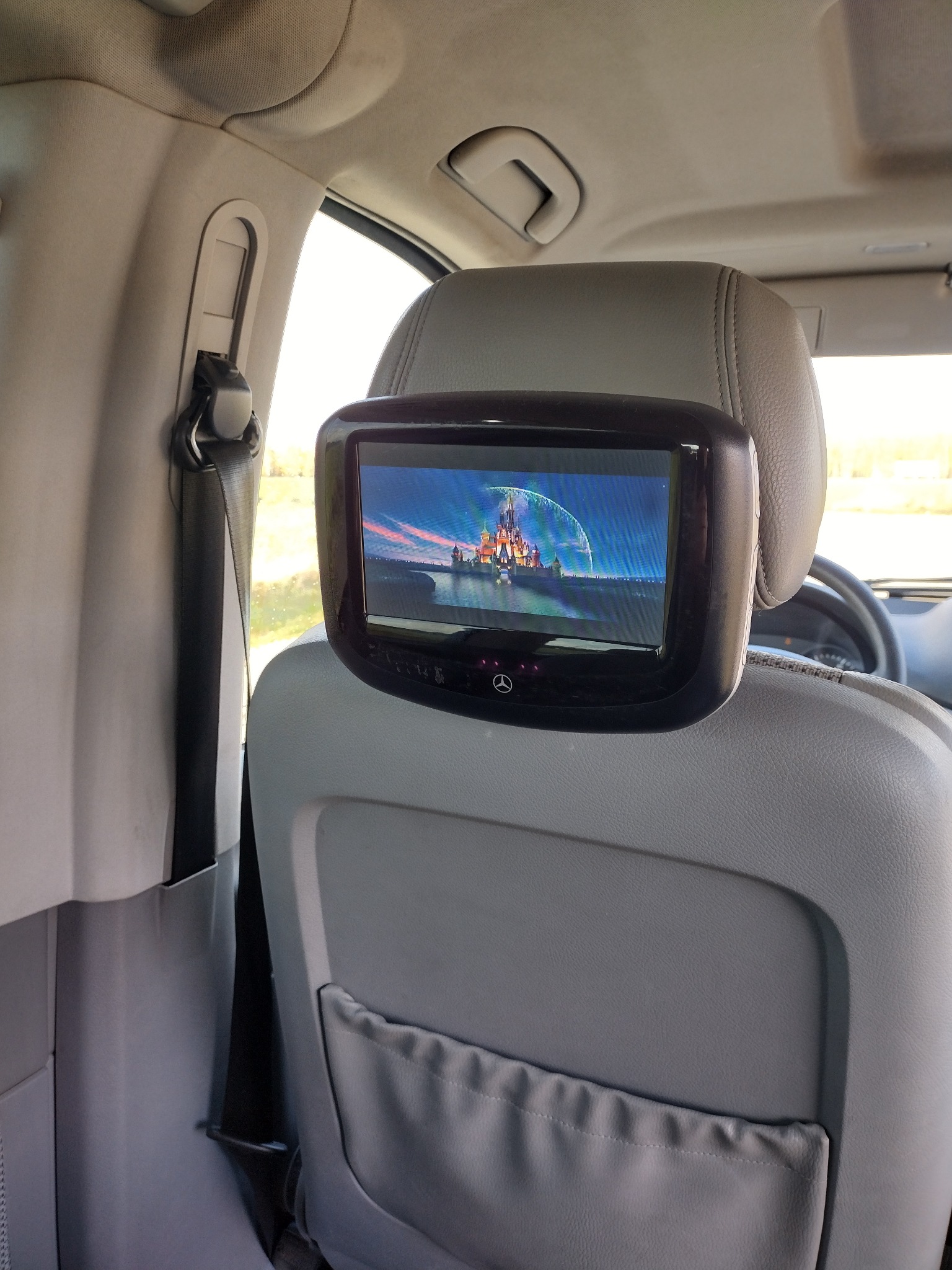 Ekran zamontowany w zagłówku fotela samochodowego wyświetla animowany obraz zamku z bajki.