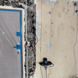 SZAR-BUD Firma remontowo budowlana Sp.z o.o. - Przygotowanie do remontu: zabezpieczone drzwi folią, odsłonięta instalacja elektryczna, ślady wilgoci i grzyba na ścianie, mieszadło do zaprawy w pomieszczeniu.