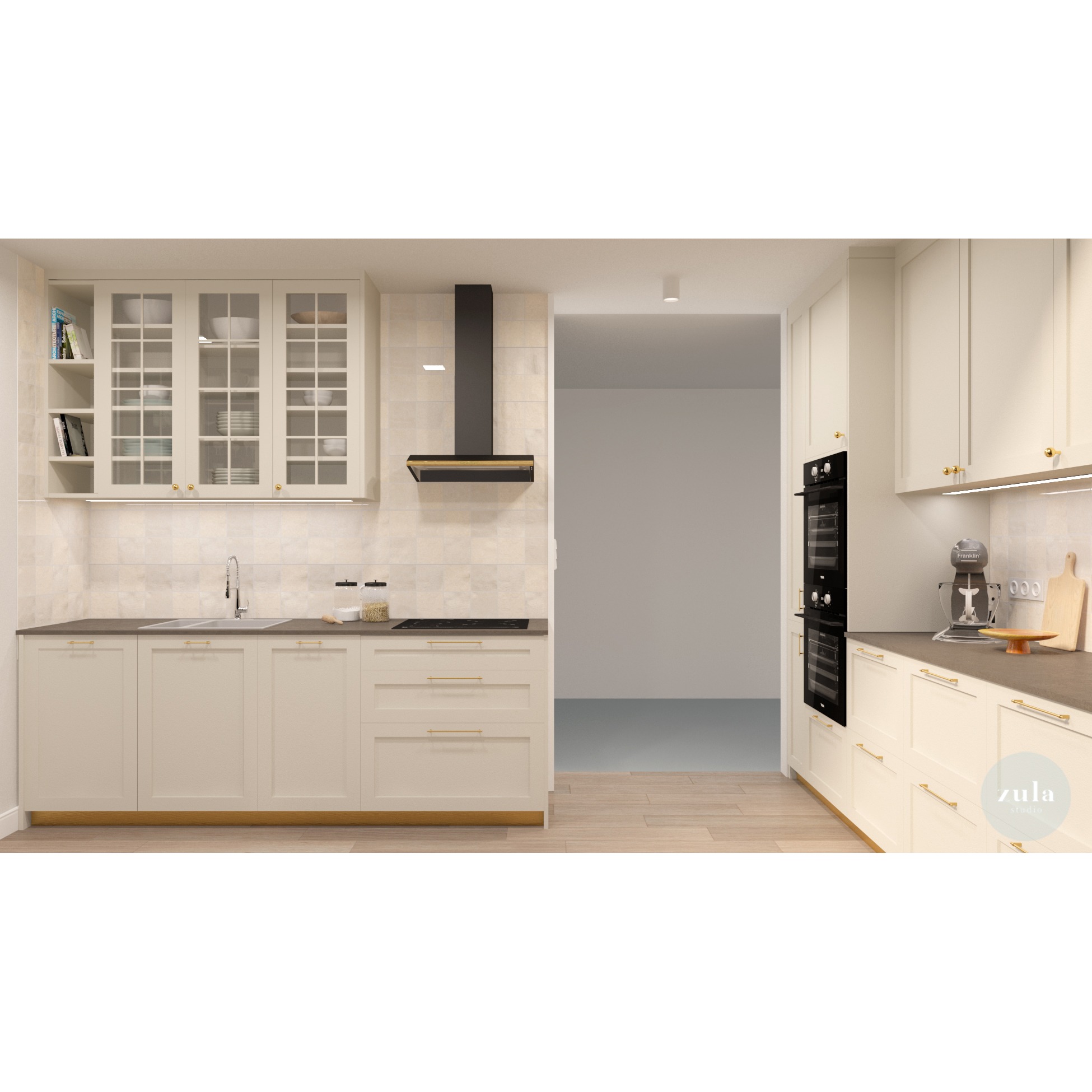 Projekt kuchni w stylu klasycznym z kremowymi szafkami, złotymi uchwytami, czarnym okapem i sprzętem AGD, widok na puste pomieszczenie obok.