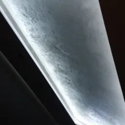 Podświetlany sufit napinany z efektem betonu, oświetlenie LED wzdłuż krawędzi, widok pod kątem z dołu.