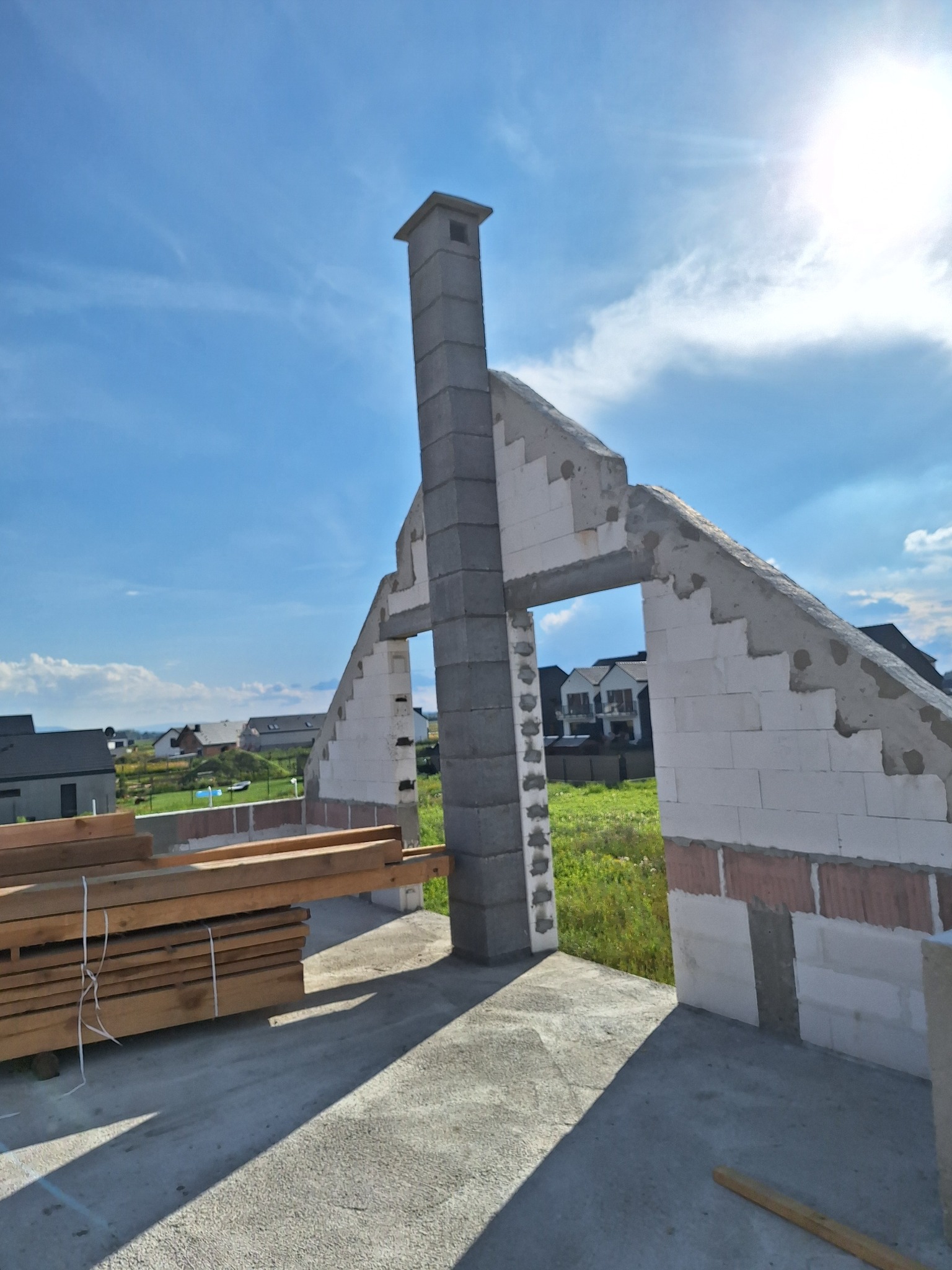 Wrocław, stan surowy otwarty domu z pustaków, widok na okolicę przez otwory okienne, drewno budowlane na pierwszym planie.