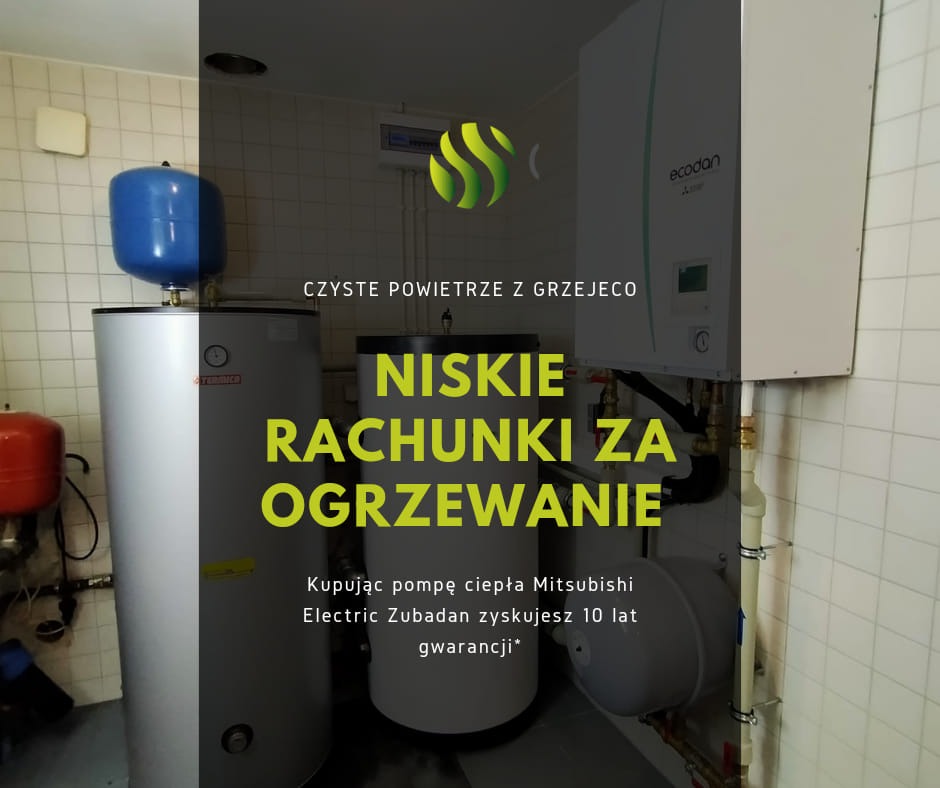 Instalacja grzewcza z zasobnikiem, pompą ciepła Mitsubishi Electric Zubadan i tekstem 'Niskie rachunki za ogrzewanie' na tle białych kafelków.