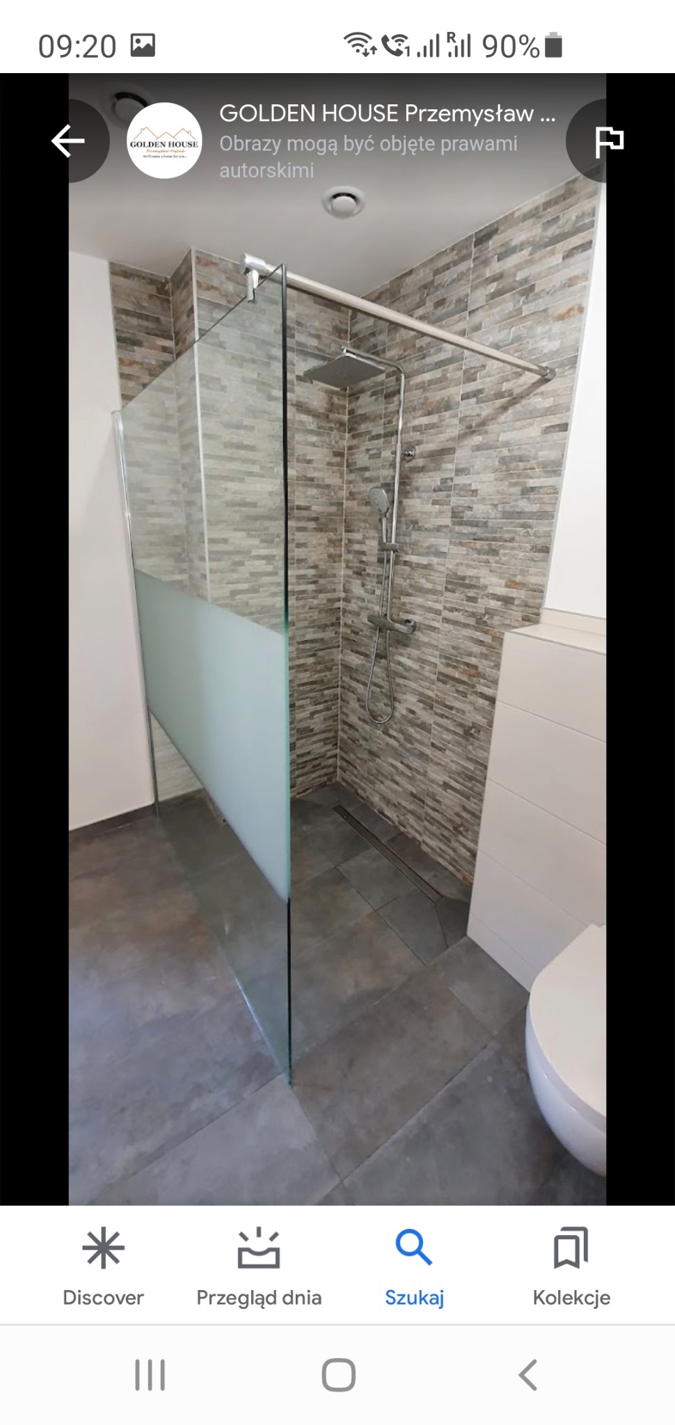 Nowoczesna kabina prysznicowa typu walk-in z częściowo matową szybą, deszczownicą i odpływem liniowym w podłodze, wykończona płytkami imitującymi kamień w odcieniach szarości i beżu, z widoczną...