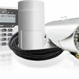 Zestaw alarmowy: centrala alarmowa z wyświetlaczem, czujnik ruchu i kamera CCTV z diodami IR oraz przewód instalacyjny, na białym tle.