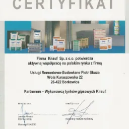 Certyfikat firmy Usługi Remontowo-Budowlane Piotr Skuza potwierdzający współpracę z Knauf, prezentujący produkty Knauf na półce.