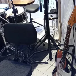 Instrumenty muzyczne: perkusja Pearl, gitara akustyczna i elektryczna Squire, statywy, krzesło perkusisty, skrzynia z logo zespołu 'Cinnamon live Cover Band'.