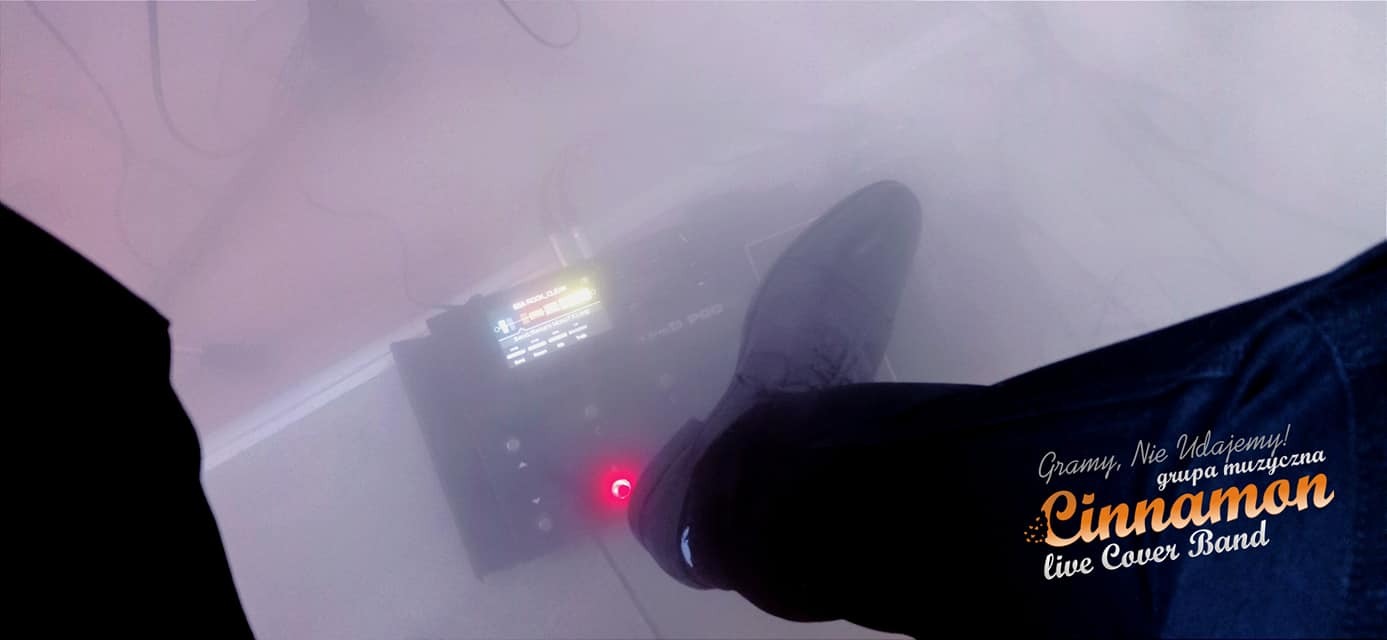 Stopa w czarnym bucie naciska pedał efektów gitarowych Line 6 POD. Widoczny wyświetlacz urządzenia i logo zespołu Cinnamon live Cover Band na ubraniu.