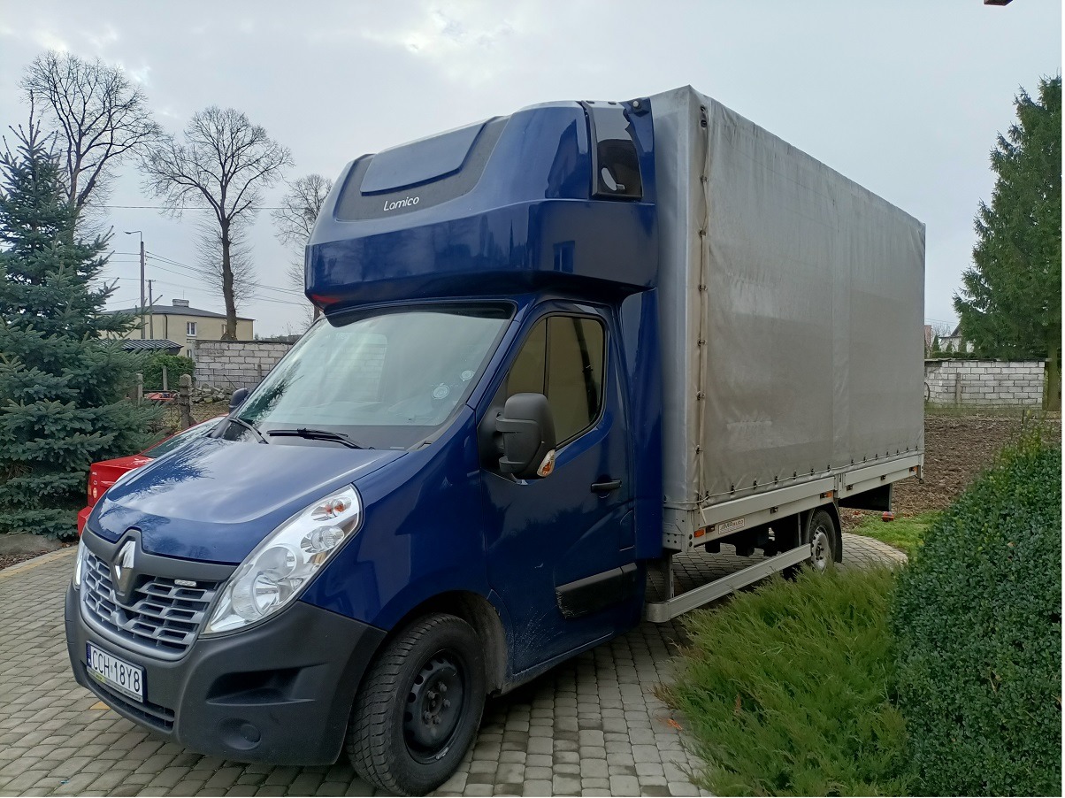 Niebieski bus Renault Master z plandeką na parkingu z kostki, widoczne tablice rejestracyjne CCH 18Y8, nadbudowa kabiny Lamico.