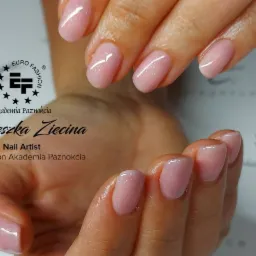 Delikatny, półtransparentny manicure żelowy w odcieniu pudrowego różu, z subtelnym połyskiem, prezentowany na tle z logo salonu Euro Fashion Akademia Paznokcia.