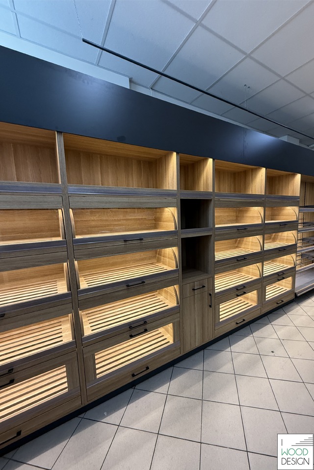 Regały piekarnicze z drewna w sklepie, oświetlone od wewnątrz, z szufladami na pieczywo. Prosta forma, nowoczesny design, widok z perspektywy klienta.