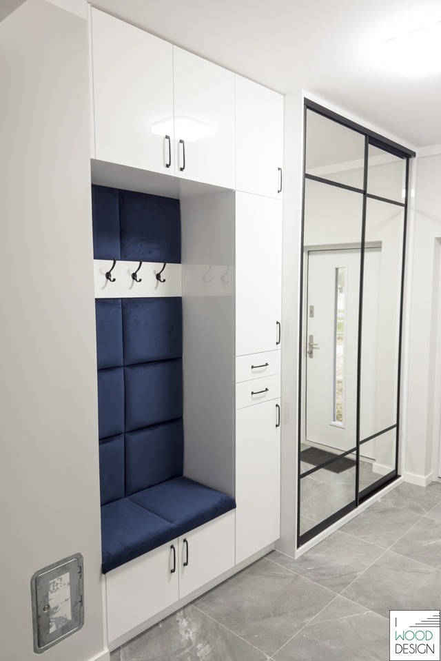 Biała szafa wnękowa z siedziskiem i lustrem w czarnej ramie, nowoczesny design. Realizacja w Białystoku. Granatowe obicie siedziska i oparcia.