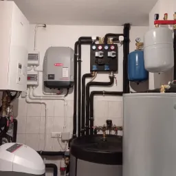 Kompleksowa kotłownia z piecem gazowym, inwerterem Fronius, zasobnikiem ciepłej wody, naczyniami przeponowymi i stacją uzdatniania wody w pomieszczeniu z płytkami ceramicznymi.