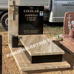 Kamieniarstwo Robert Didyk - Jasny nagrobek z ciemną tablicą, złotym krzyżem i zdjęciem osoby zmarłej. Widoczny fragment samochodu dostawczego z nazwą firmy kamieniarskiej.