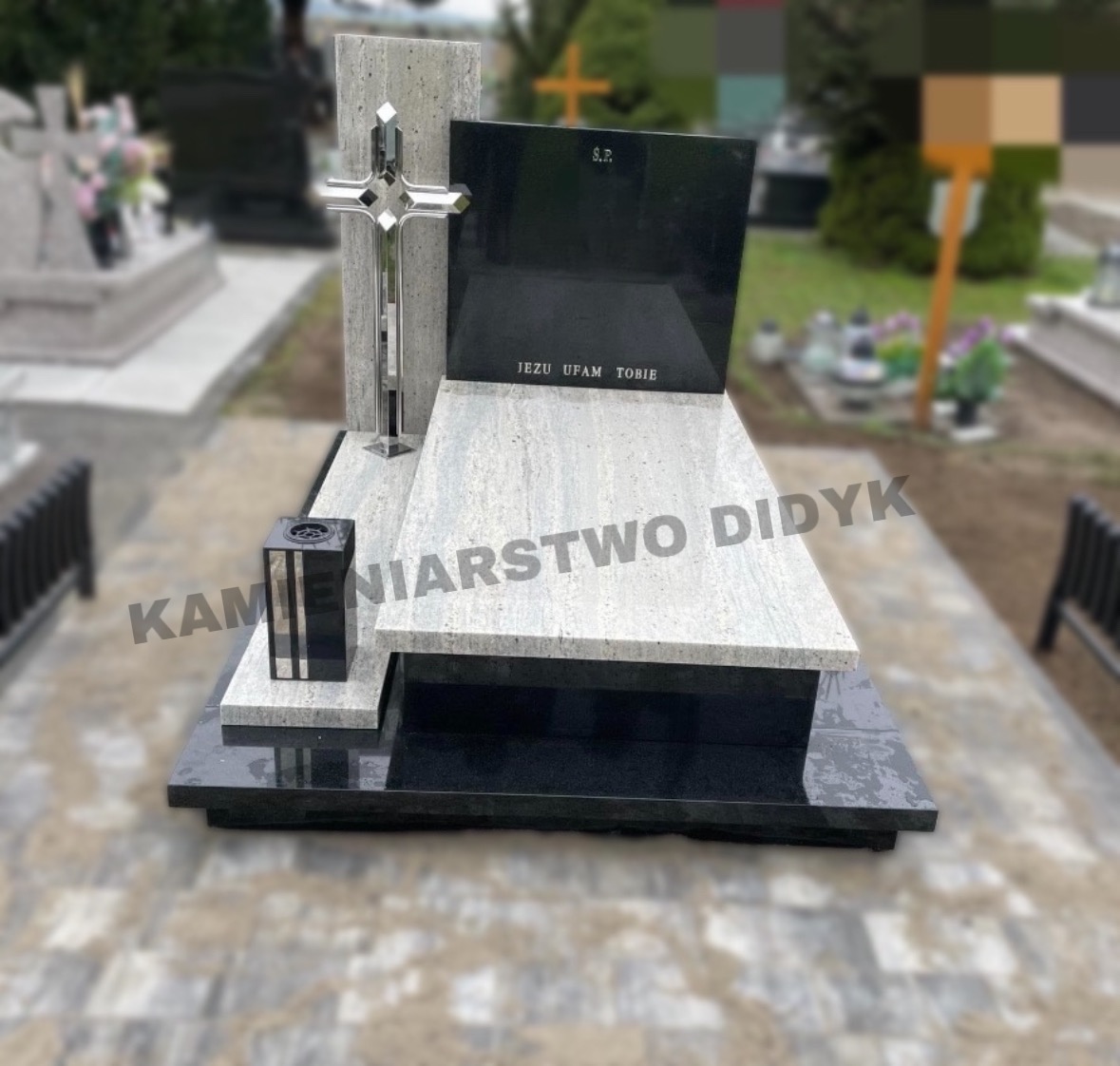 Granitowy pomnik nagrobny z chromowanym krzyżem i czarnym lampionem, napisem 'Jezu Ufam Tobie' i tablicą z inicjałami 'Ś.P.'