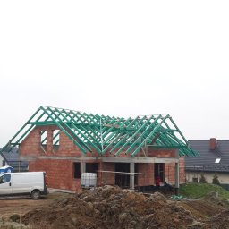 Dar-Bud Usługi Remontowo Budowlane - Surowy stan domu w trakcie budowy z czerwonej cegły z zielonymi elementami więźby dachowej, biały samochód dostawczy i pryzma ziemi na pierwszym planie.