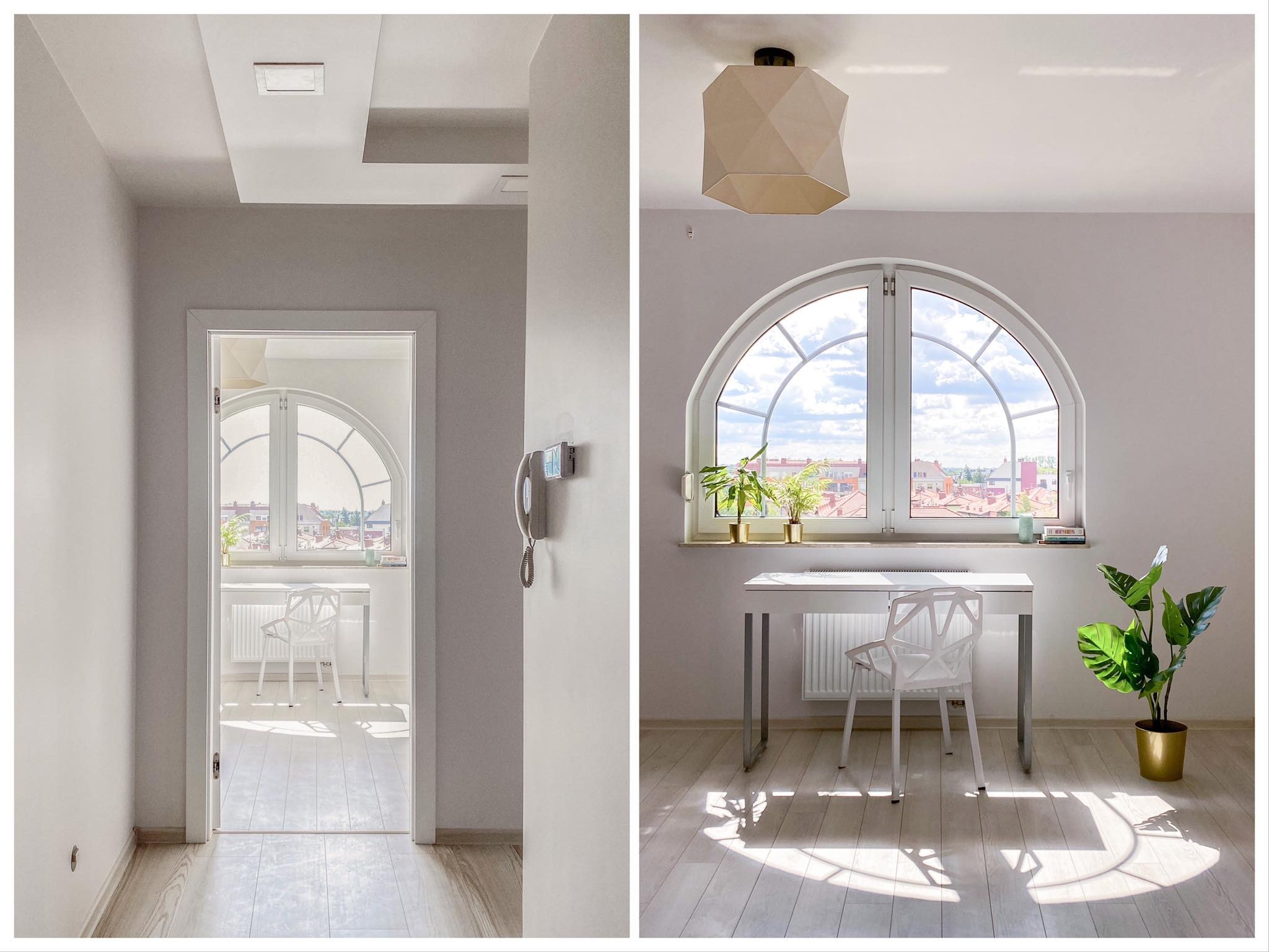 Jasny pokój z białym biurkiem, krzesłem i roślinami, widok z korytarza przez otwarte drzwi, okno łukowe z widokiem na miasto, drewniana podłoga z promieniami słońca.