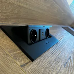 Wpuszczane w blat drewniany gniazdo elektryczne z dwoma portami USB.