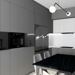 Studio 4.0 - Projektowanie wnętrz - Nowoczesna kuchnia w odcieniach szarości z czarnym blatem stołu i minimalistycznym oświetleniem, widoczne wbudowane sprzęty AGD i krzesła tapicerowane szarą tkaniną.