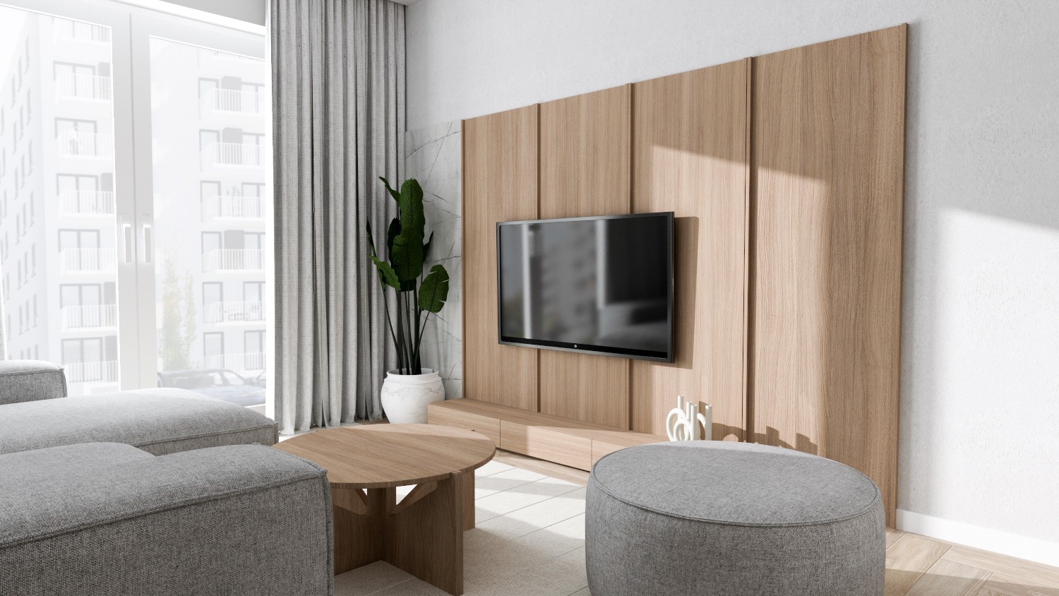 Nowoczesny salon z drewnianą ścianą panelową, telewizorem, szarą sofą modułową, okrągłym stolikiem kawowym i pufem, doświetlony dużym oknem z widokiem na budynek mieszkalny.