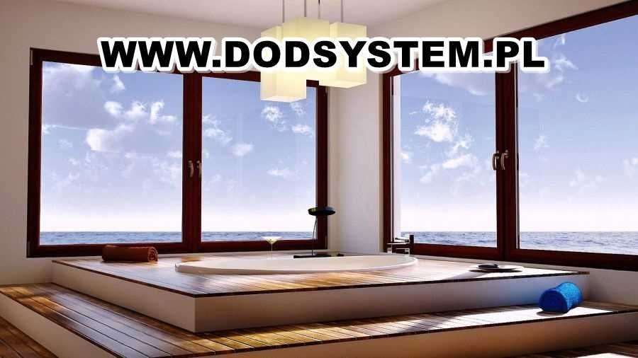 Nowoczesna łazienka z oknami z ciemnego drewna z widokiem na morze, wanna na podwyższeniu z drewnianym wykończeniem, minimalistyczna lampa sufitowa.