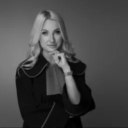 Portret kobiety w todze z żabotem, z dłonią pod brodą, na jednolitym szarym tle, w czerni i bieli.