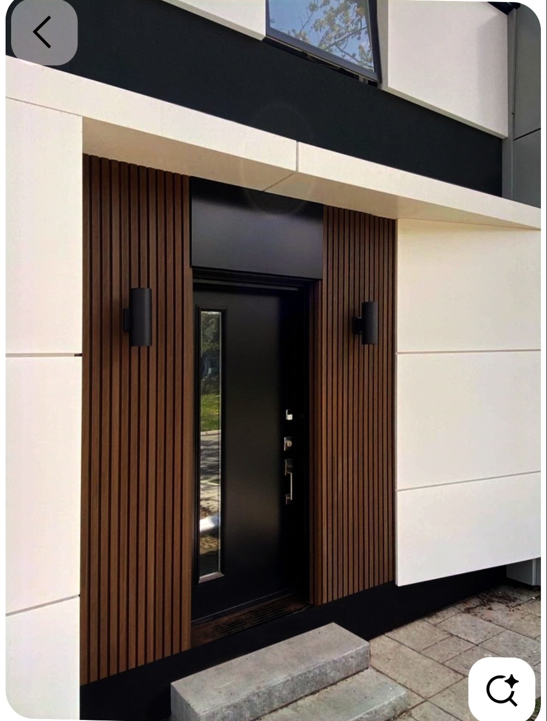 Nowoczesna elewacja domu z czarnymi drzwiami wejściowymi, drewnianymi panelami i białymi płytami elewacyjnymi. Minimalistyczny design z oświetleniem zewnętrznym.