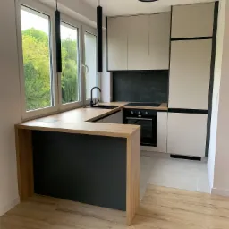 Nowoczesna kuchnia z blatem drewnianym w Chełmcu, z czarnymi akcentami i oświetleniem punktowym, widok z perspektywy podłogi.