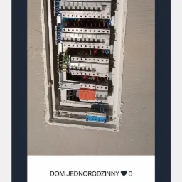 Rozdzielnica elektryczna wnękowa z zamontowanymi bezpiecznikami i okablowaniem, widok po częściowym wykończeniu ściany.