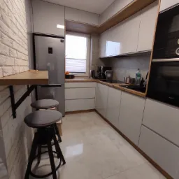 Nowoczesna kuchnia z białymi, połyskującymi szafkami, drewnianym blatem i barkiem przymocowanym do ściany z cegły, uzupełniona dwoma ciemnymi stołkami barowymi.