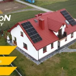 Dom jednorodzinny z czerwoną dachówką, na której zainstalowano panele fotowoltaiczne; widok z lotu ptaka, logo firmy Hyperion Energy w lewym górnym rogu.